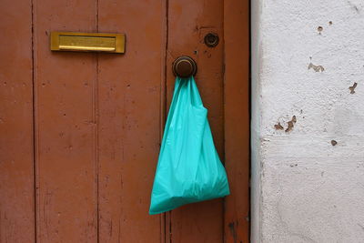 Detail of portuguese rustic wooden door with plastic bag hanging.