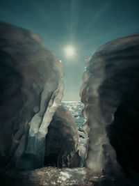 Rock formation in sea against sky