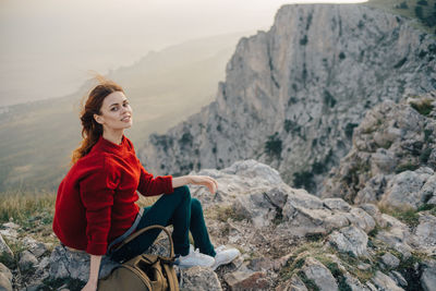 Young woman sitting on rock