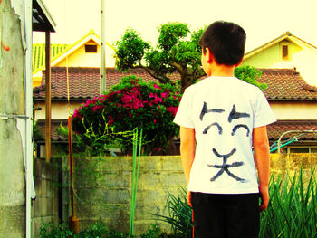 Rear view of man standing by house