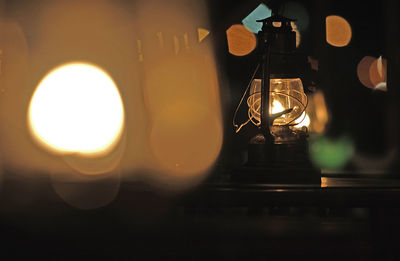 Close-up of illuminated light bulb on table