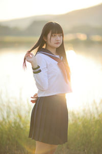 Portrait of young woman standing on field