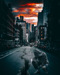 Road amidst buildings against sky during sunset