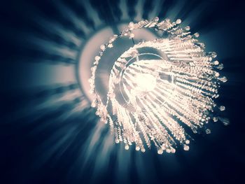 Low angle view of illuminated chandelier against sky at night