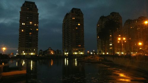 Illuminated buildings against sky at night