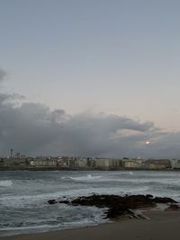 Scenic view of sea by buildings against sky