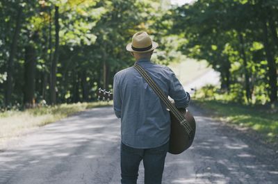 Rear view of man walking on road