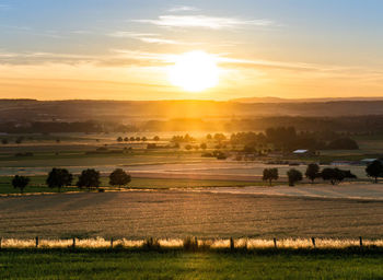 Scenic view of field against sky during sunset