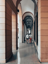 Rear view of man walking in corridor of building