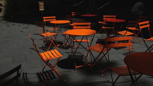 Orange chairs and tables at sidewalk cafe