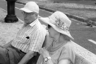 Elderly couple sitting on a bench by the lake. black and white photo.