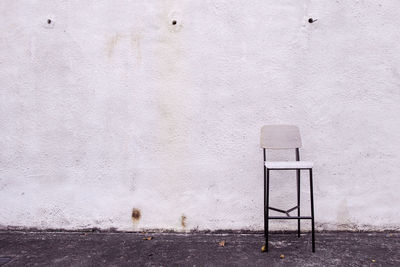 Empty chair against wall