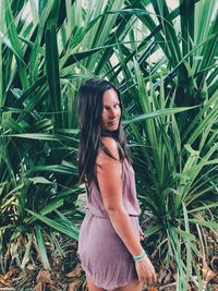 Portrait of woman standing against plants