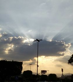 Low angle view of street light against cloudy sky