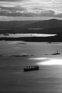 Scenic view of sea with little ship against sky