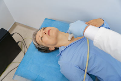 High angle view of young woman with iv drip at home