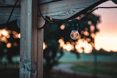 Illuminated light bulb hanging by pole