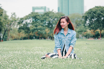 Young woman smiling while standing on field