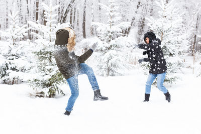 People on snow covered trees during winter