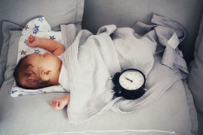 High angle view of baby boy sleeping on bed at home