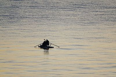 Silhouette man on boat in sea