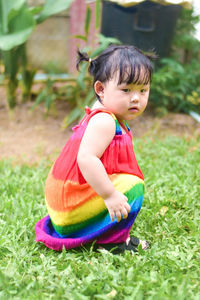 Portrait of cute girl sitting on field