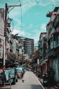 Cars on street in city against sky