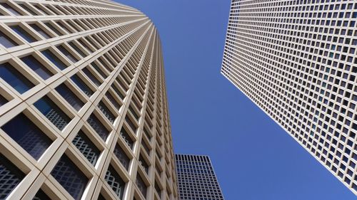 Low angle view of modern buildings against clear blue sky