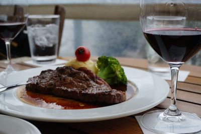 Steak with red wine served on table