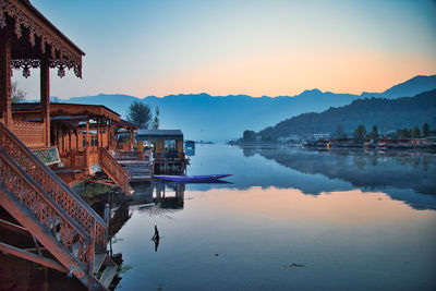 Panoramic view of lake by buildings against sky during sunset