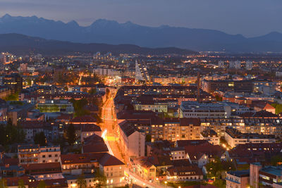 Illuminated cityscape against sky at dusk