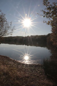 Scenic view of lake against bright sun