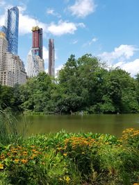 Scenic view of lake by buildings against sky