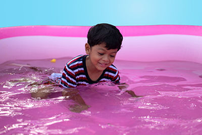 Full length of boy enjoying in wading pool