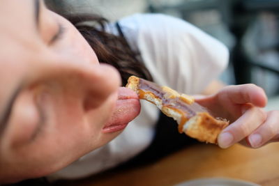 Close-up of mid adult woman eating food at home