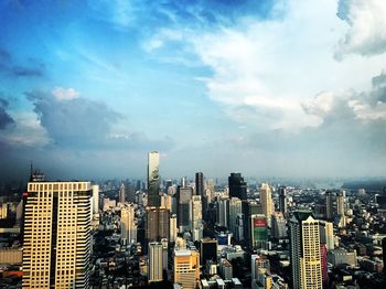 View of cityscape against cloudy sky