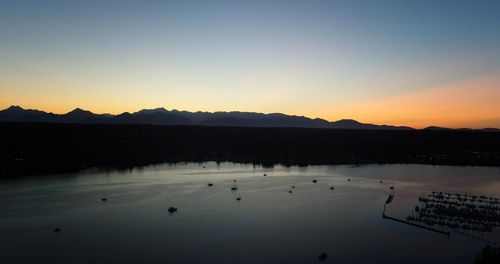 Scenic view of lake against clear sky during sunset