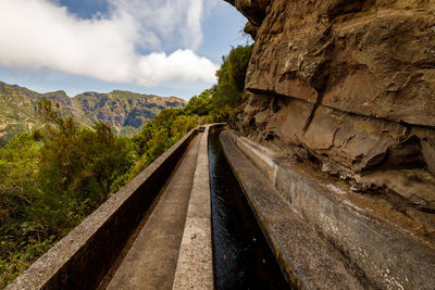 Railroad tracks amidst mountains against sky