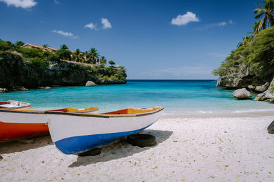 Boat moored on beach against sky