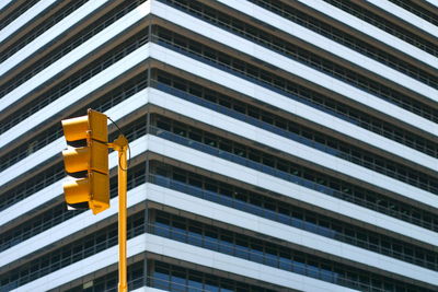 Low angle view of road signal against modern building in city