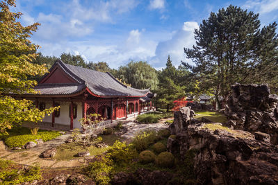 Traditional building by trees against sky