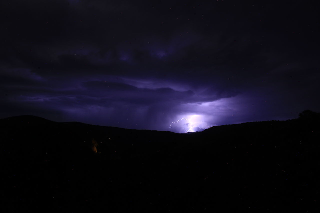 night, sky, cloud, beauty in nature, darkness, lightning, power in nature, mountain, storm, scenics - nature, environment, thunderstorm, dramatic sky, nature, silhouette, dark, no people, landscape, star, thunder, storm cloud, outdoors, awe, warning sign, illuminated, light, atmospheric mood, mountain range