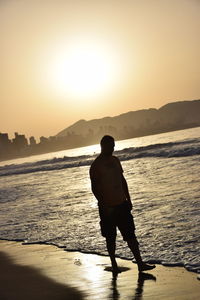 Rear view of man standing on beach