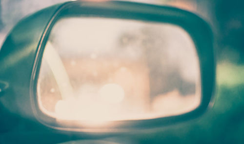 Close-up of camera reflection on side-view mirror