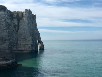 Scenic view of rock formation in sea against sky