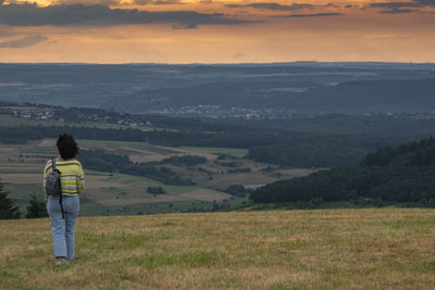 Rear view of woman standing on mountain