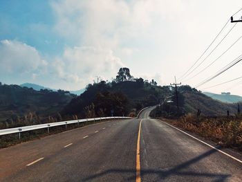 Road leading towards mountain against sky