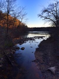 Scenic view of lake against sky at sunset