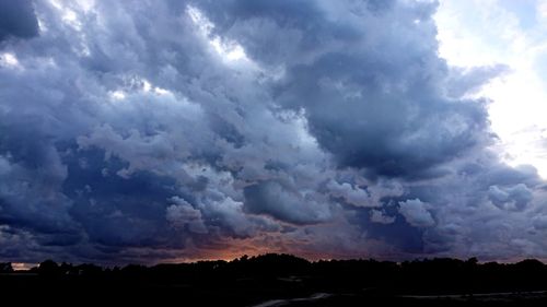 Scenic view of dramatic sky over silhouette landscape