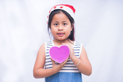 Portrait of a girl holding heart shape